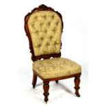 A Victorian walnut nursing chair with upholstered seat and back, on turned front supports.