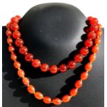 A carnelian bead necklace with 9ct gold clasp, 37cms (14.5ins) long; together with another