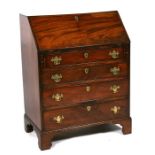 A George III mahogany bureau of small proportions, the fall front enclosing a fitted interior