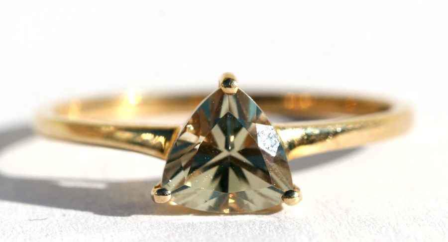 A 9ct gold dress ring set with a triangular cut pale yellow stone, approx UK size 'R'.