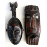 An African carved hardwood mask; together with another similar.