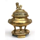 A Chinese polished bronze censer on stand, the pierced cover with lion finial and two lion mask