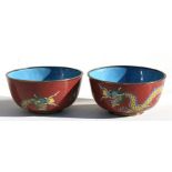 A pair of Chinese cloisonne bowls decorated with dragons on a red ground, 11cms (4.25ins) diameter.