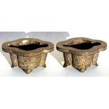 A pair of Chinese brass planters of lobed form, decorated with foliate scrolls and standing on