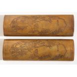 A pair of Chinese patinated bronze wrist rests decorated with a figure in a landscape with four-