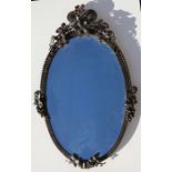 An oval wall mirror decorated with grapes & foliage, 82.5cms (32.5ins) high.