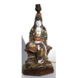 A Japanese Satsuma figural table lamp in the form of a seated robed lady holding a lotus flower,