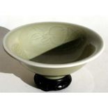 A Chinese celadon glazed bowl on stand decorated with fruit & flowers, 20cms (8ins) diameter.