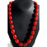 A cherry amber Bakelite necklace comprising twenty seven graduated oval beads, the largest 22mm