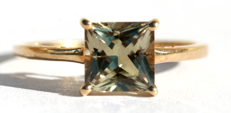 A 9ct gold dress ring set with a single square pale yellow stone, approx UK size 'Q'.