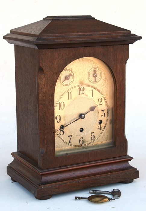 An early 20th century oak case mantle clock, the brass dial with Arabic numerals, 28cms (11ins)