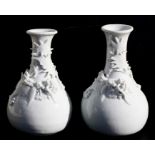 A pair of Chinese blanc de chine vases, each decorated with an applied coiled dragon, 20cms (8ins)