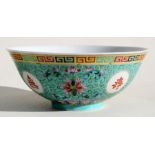 A Chinese famille rose footed bowl decorated with flowers & calligraphy on a turquoise ground, 18.
