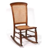 A late 19th century walnut rocking chair with caned seat & back.