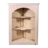 A painted pine freestanding corner cupboard with shaped shelves, 109cms (43ins) wide.