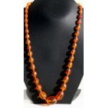 An amber like necklace comprising forty four graduated faceted oval beads, the largest 26cmm.