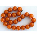 An amber like necklace comprising twenty four spherical beads, 12mm wide.Condition Report Weight