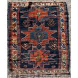 A Caucasian rug decorated with three central guls within a geometric border on a blue ground, 97
