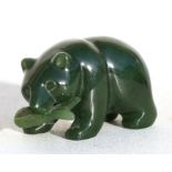 A Canadian Inuit jade figure in the form of a bear holding a salmon in his mouth, 5cms (2ins) long.