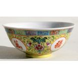 A Chinese famille rose footed bowl decorated with flowers and calligraphy, on a yellow ground, 11.