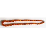 An amber bead necklace with thirty nine oval beads, 48cms (18.75ins) long. Largest bead 12mm long.