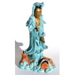 A Chinese porcelain figure of Guanyin standing on the back of a water dragon, 37cms (14.5ins) high.