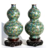 A pair of Chinese cloisonne double gourd vases decorated with fruit and flowers on a turquoise