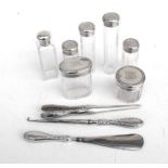 An Edwardian silver dressing table set, London 1905, to include a button hook, a shoe horn, glove