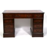 A reproduction mahogany pedestal desk with an arrangement of nine drawers, on plinth base, 121cms (