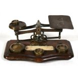 A pair of Victorian brass and oak letter scales & weights, 18.5cms (7.25ins) wide.