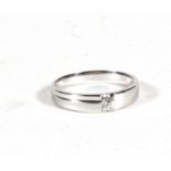 An 18ct white gold modern design ring set with a single diamond. Approx UK size L