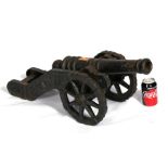 An impressive cast iron signal cannon, sitting on a cast iron carriage and wheels. Having a coat
