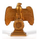 A gold plated Third Reich Nuremberg Eagle mounted on a later wooden base. This item has been