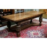 A large Jacobean style oak draw-leaf refectory table on twin carved bulbous legs joined by a
