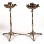 A pair of silver plated W A S Benson candlesticks with copper leaf shaped sconce, on tripod legs,