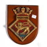 A hand painted aluminium ships crest or plaque mounted on a wooden shield to HMS Maidstone.