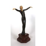 An Art Deco style bronzed figure depicting a lady wearing a long dress, mounted on a rouge marble