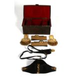 Epaulettes, bicorn hat and sword belt with hangers contained in its black japanned tin with plaque