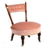 A Victorian walnut nursing chair with upholstered seat and back, on turned front supports.