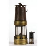 A brass and steel miners lamp, numbered '887', 24cms (9.5ins) high; together with a miniature miners