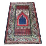 A Persian prayer rug with stylised foliate border, on a blue ground, 121 by 198cms (47.5 by 78ins).