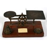 A large sized set of brass postal scales on an oak base, with stacking brass weights, 32cms (12.