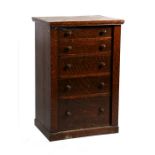 An oak Wellington chest with five long graduated drawers, on plinth base, 69cms (24ins) wide.