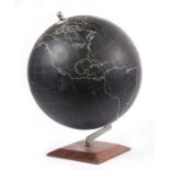 A vintage metal globe of the world, on a matt black ground standing on a hardwood plinth, 38cms (