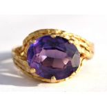 An 18ct gold bark effect cocktail ring set with a large central amethyst, approx UK size 'P'.