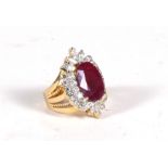 An 18ct gold ring (stamped 750) set with a large central oval ruby surrounded by marquise,
