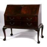A 19th century mahogany bureau on stand, the fall flap enclosing a fitted interior above two long