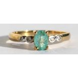 A 9ct gold ring set with a central oval pale green stone and diamond shoulders, approx UK size 'N'.