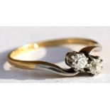 An 18ct gold and platinum two-stone diamond crossover ring, approx UK size 'M'.