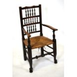 A Lancashire spindle back carver chair with rush seat.